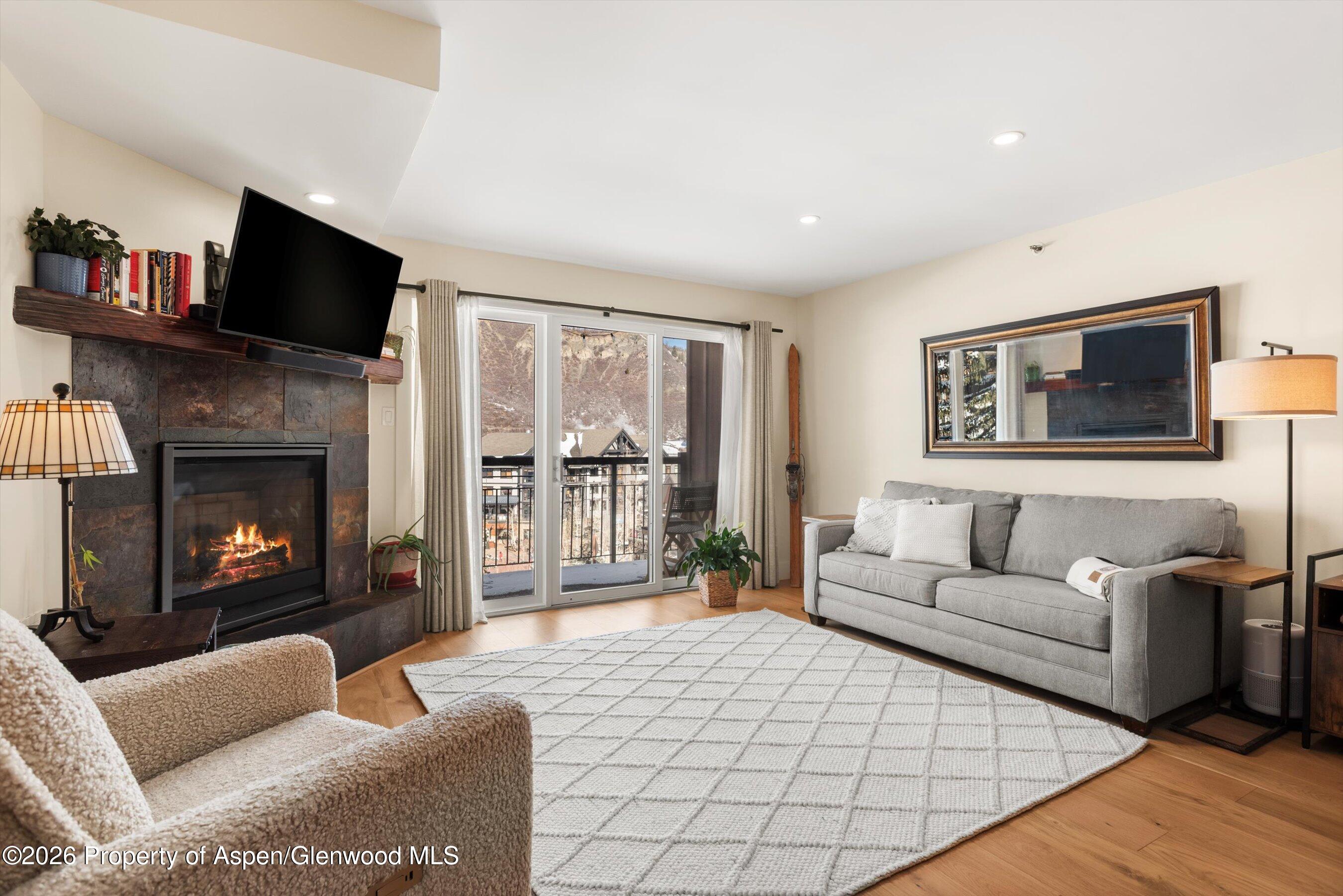 400 Wood Road, Unit D1206 Snowmass Village, CO 81615 - Photo 2 of 12 a living room with furniture a flat screen tv and a fireplace