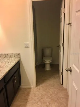 a view of a hallway with wooden floor and a bathroom