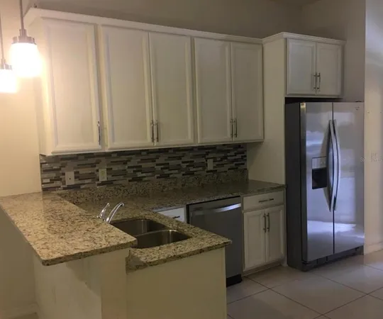 a kitchen with granite countertop a sink stainless steel appliances and cabinets
