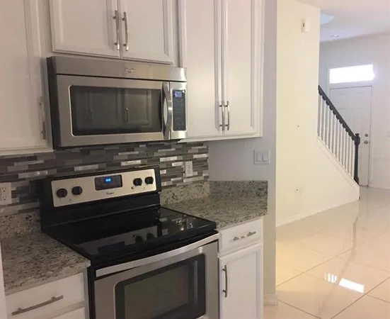 a stove top oven sitting inside of a kitchen