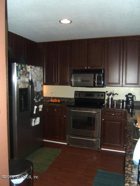 9745 Touchton Road, Unit 2726 Jacksonville, FL 32246 - Photo 3 of 5 a kitchen with granite countertop stainless steel appliances and wooden cabinets