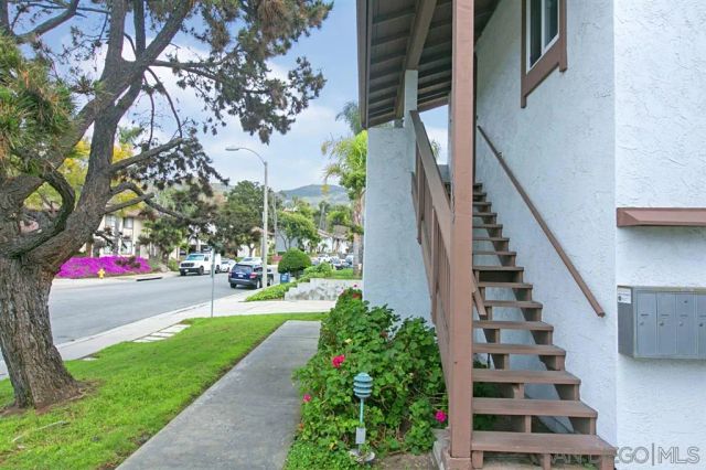 a view of a house with a yard and potted plants
