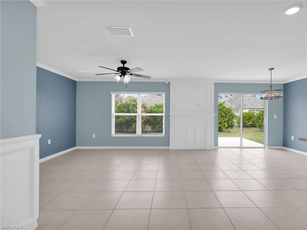 731 Hadley Place West Naples, FL 34104 - Photo 12 of 30 Great Room With Custom Woodwork Wall Feature, Crown Molding, Ceiling Fan, Chandelier, Tile Flooring, Faux Wood Blinds, and Sliders onto Patio