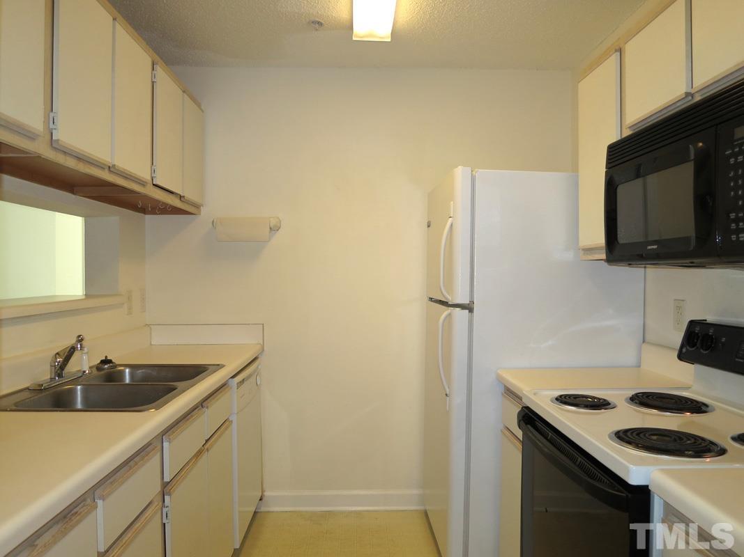 303 Smith Level Road, Unit F11 Chapel Hill, NC 27516 - Photo 5 of 14 a kitchen with a sink and a refrigerator