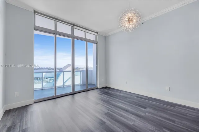 a view of empty room with wooden floor and window