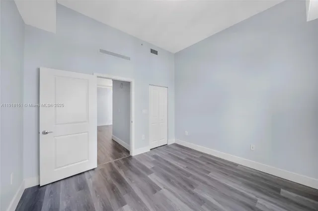 a view of empty room with wooden floor