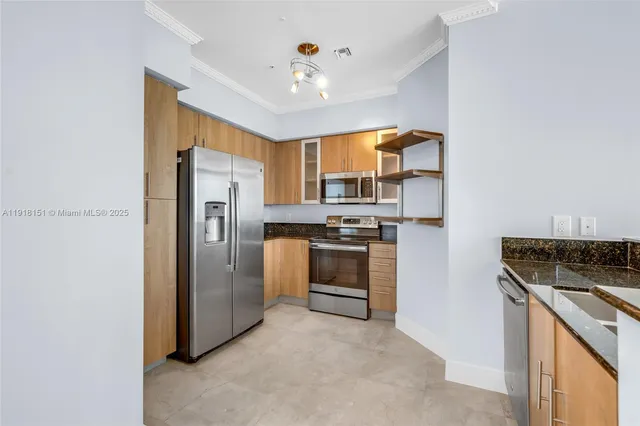 a kitchen with stainless steel appliances granite countertop a refrigerator and a stove
