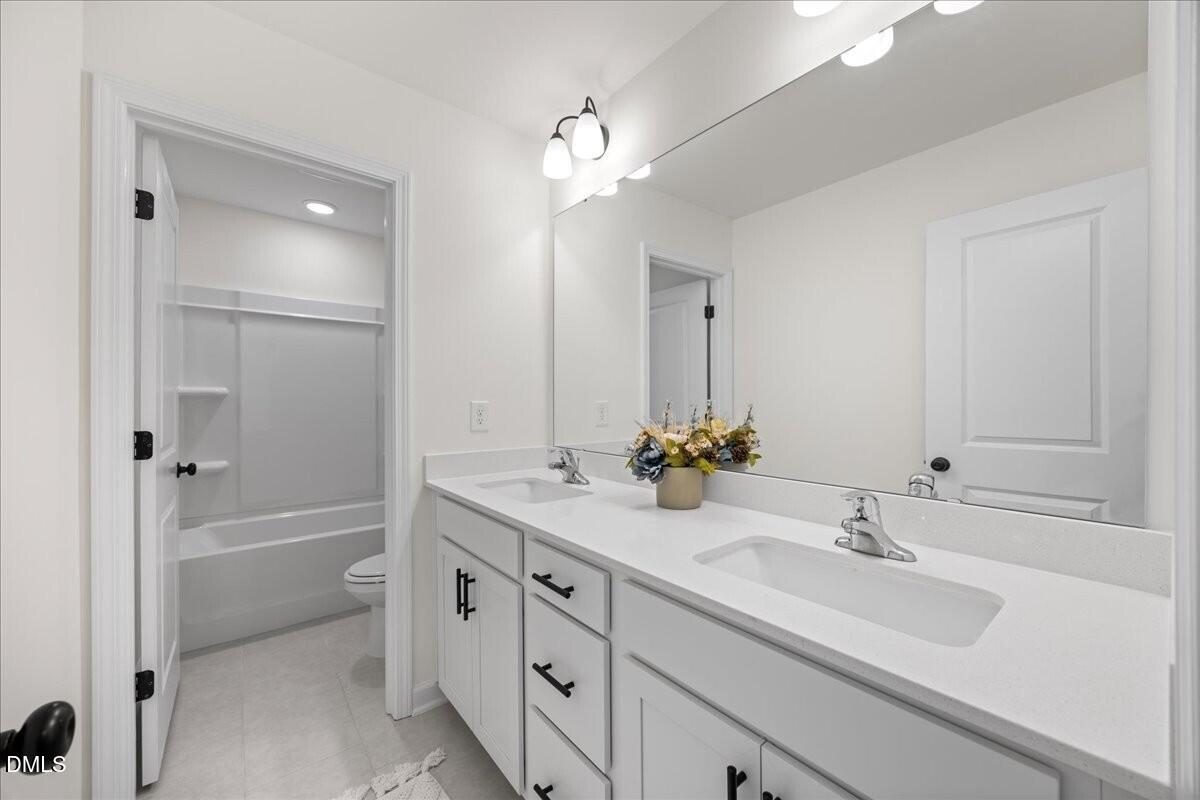653 Craftsman Rdg Trail Knightdale, NC 27545 - Photo 19 of 50 a bathroom with a double vanity sink a mirror and a bathtub
