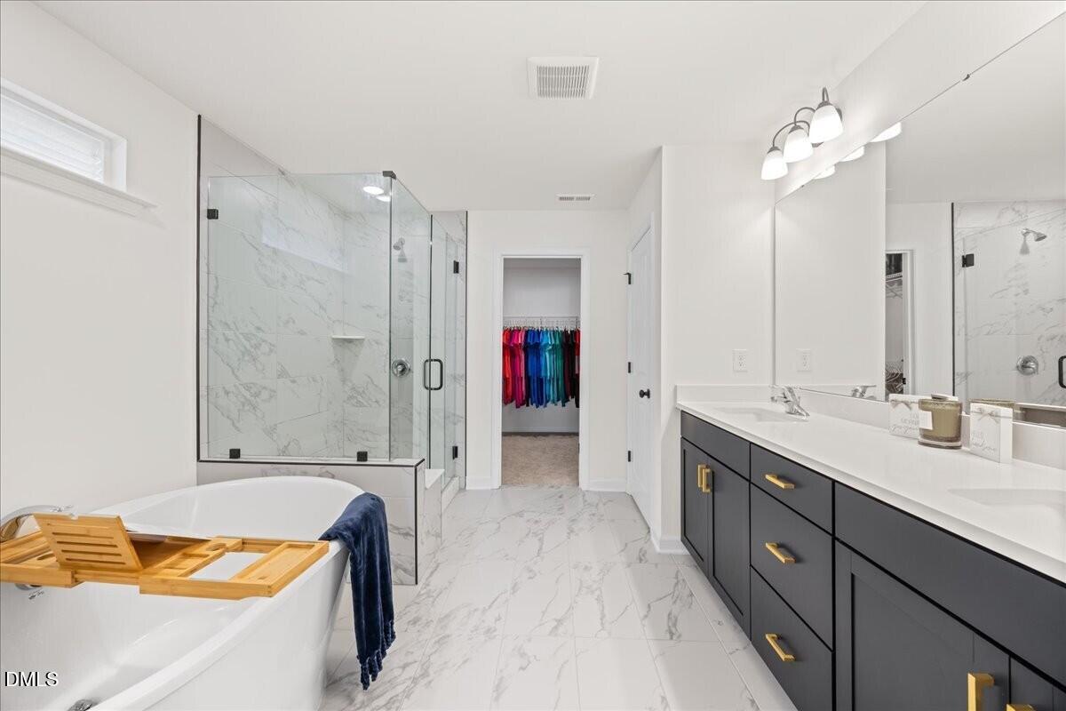 653 Craftsman Rdg Trail Knightdale, NC 27545 - Photo 24 of 50 a spacious bathroom with a tub sink shower and mirror