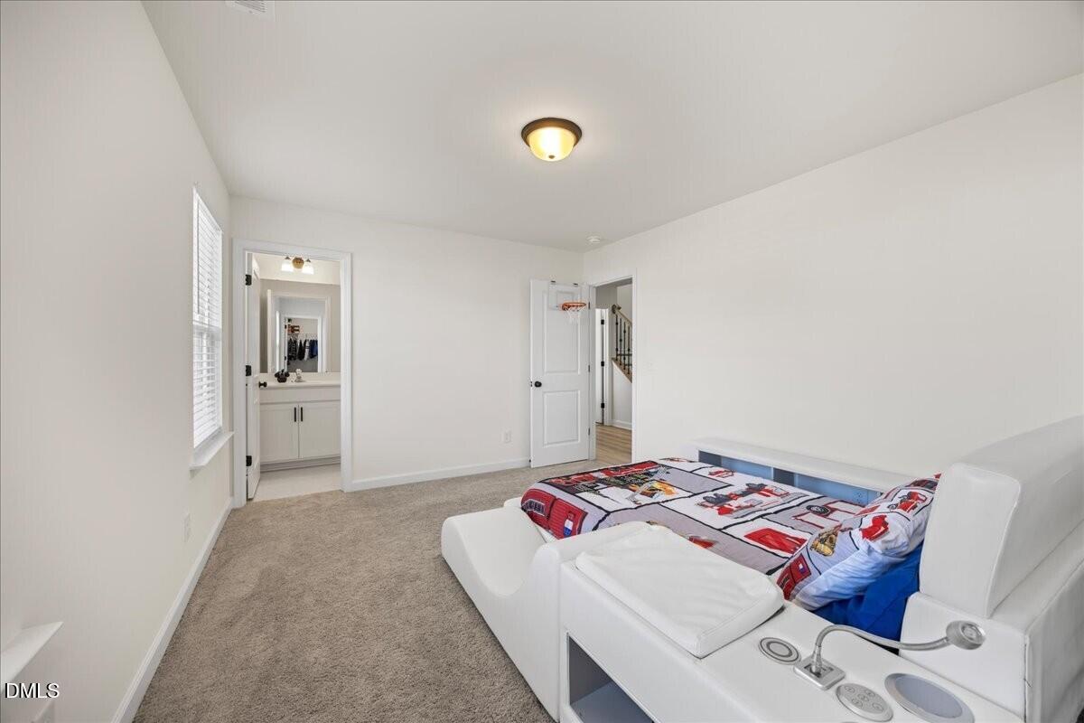 653 Craftsman Rdg Trail Knightdale, NC 27545 - Photo 34 of 50 a bedroom with a bed and a lamp