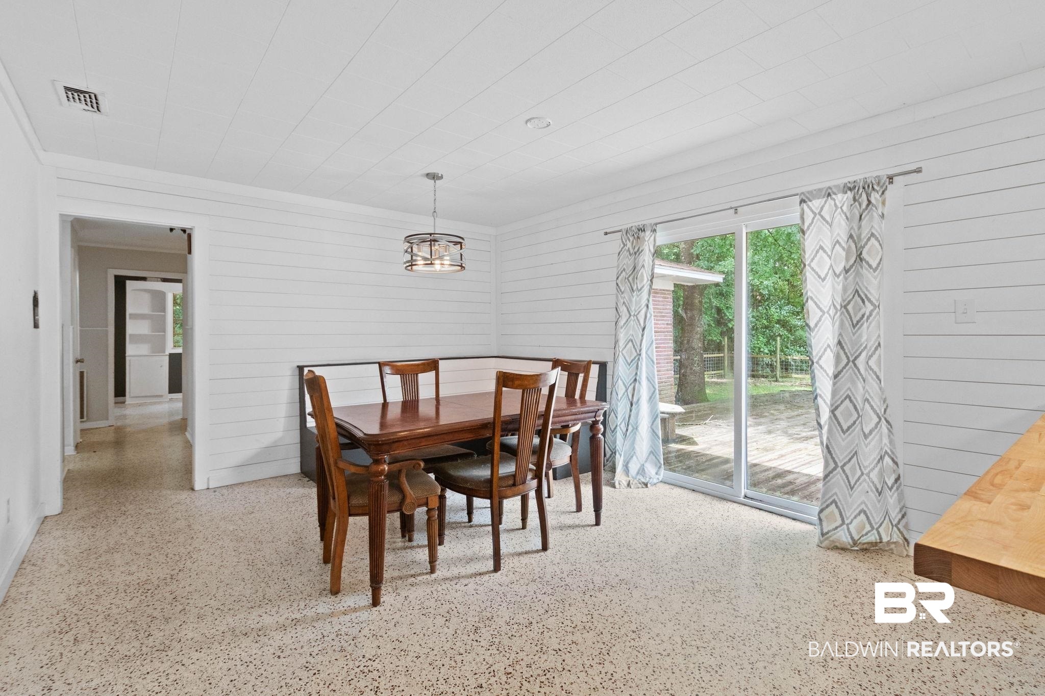 384 Old Bratt Road Atmore, AL 36502 - Photo 26 of 64 Dining area featuring shiplap walls, a suspended drum chandelier, and light-colored terrazzo flooring