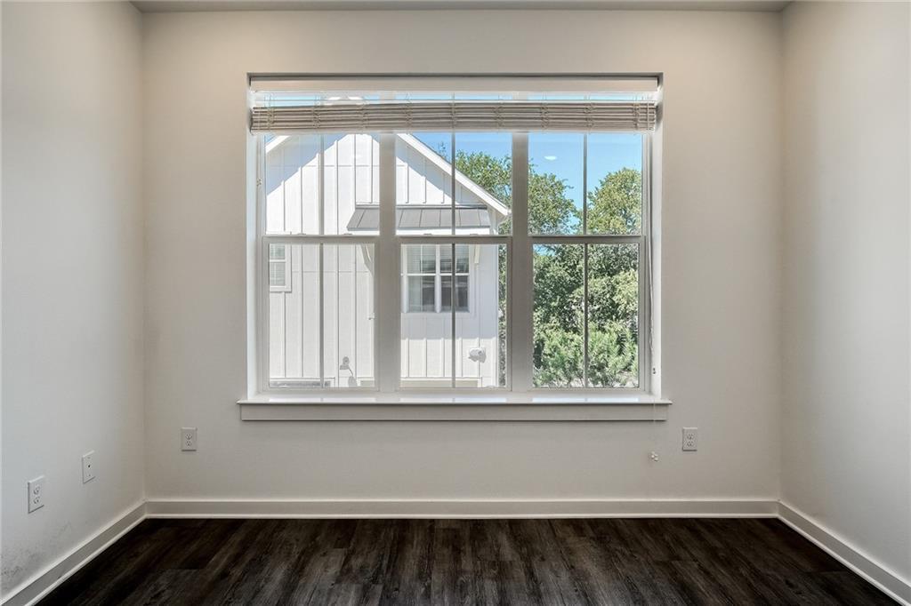 2624 Metcalfe Road, Unit 7 Austin, TX 78741 - Photo 18 of 31 Windowed wall with a multi-pane window, white trim, and dark wood-finish flooring