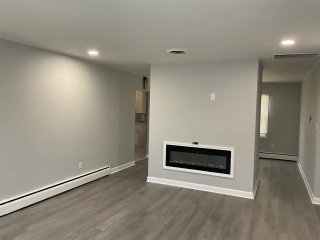 an empty room with wooden floor and fireplace