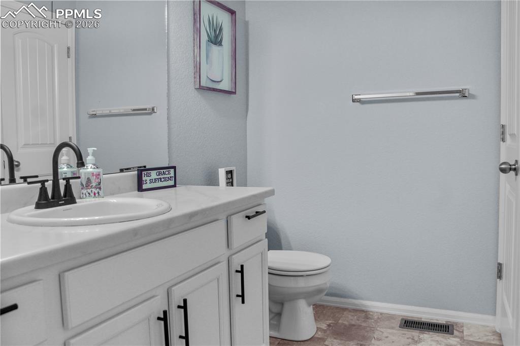7649 Grand Fir Point Colorado Springs, CO 80908 - Photo 19 of 19 a bathroom with a sink mirror vanity and toilet