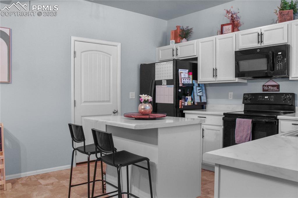 7649 Grand Fir Point Colorado Springs, CO 80908 - Photo 2 of 19 a kitchen with stainless steel appliances a stove a microwave a sink and cabinets