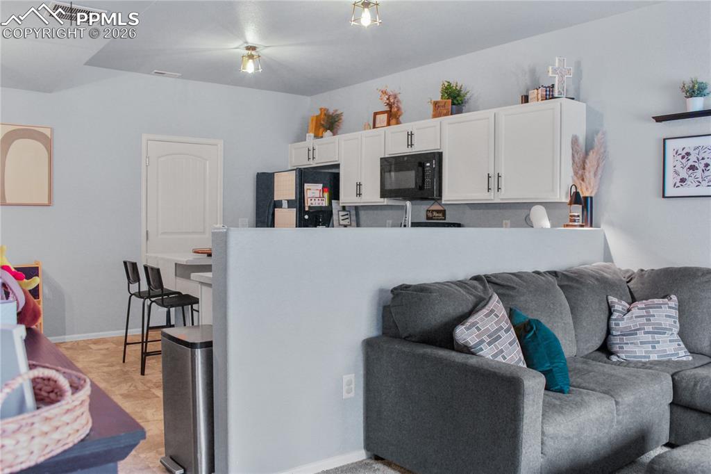 7649 Grand Fir Point Colorado Springs, CO 80908 - Photo 3 of 19 a living room with furniture and a flat screen tv