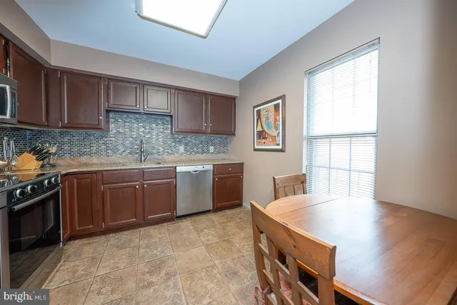 a kitchen with stainless steel appliances granite countertop a stove a sink dishwasher and a refrigerator