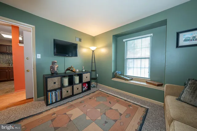 a living room with furniture a flat screen tv and a window