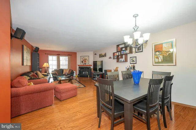 a view of a livingroom and dining room with furniture wooden floor a chandelier