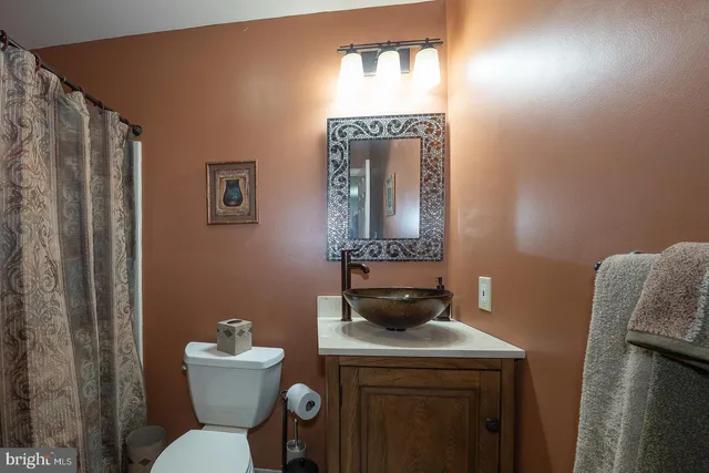 a bathroom with a toilet a sink and a mirror