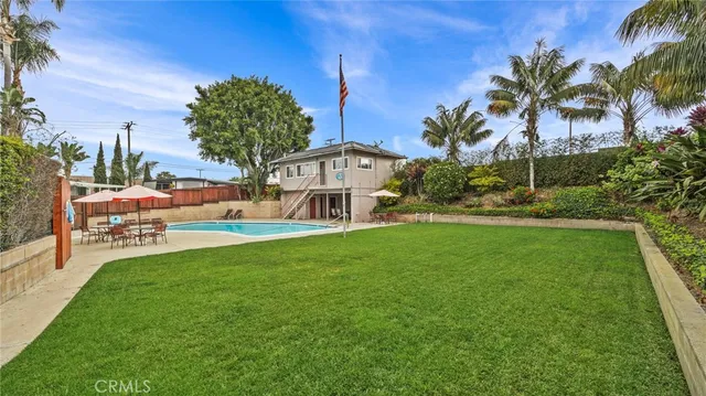 a dining room with furniture potted plants and wooden floor