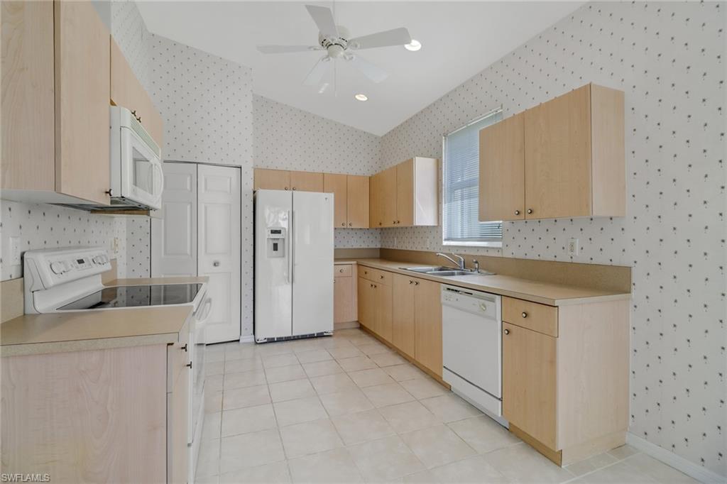 9373 Springview Loop Estero, FL 33928 - Photo 11 of 35 a kitchen with a sink cabinets and refrigerator
