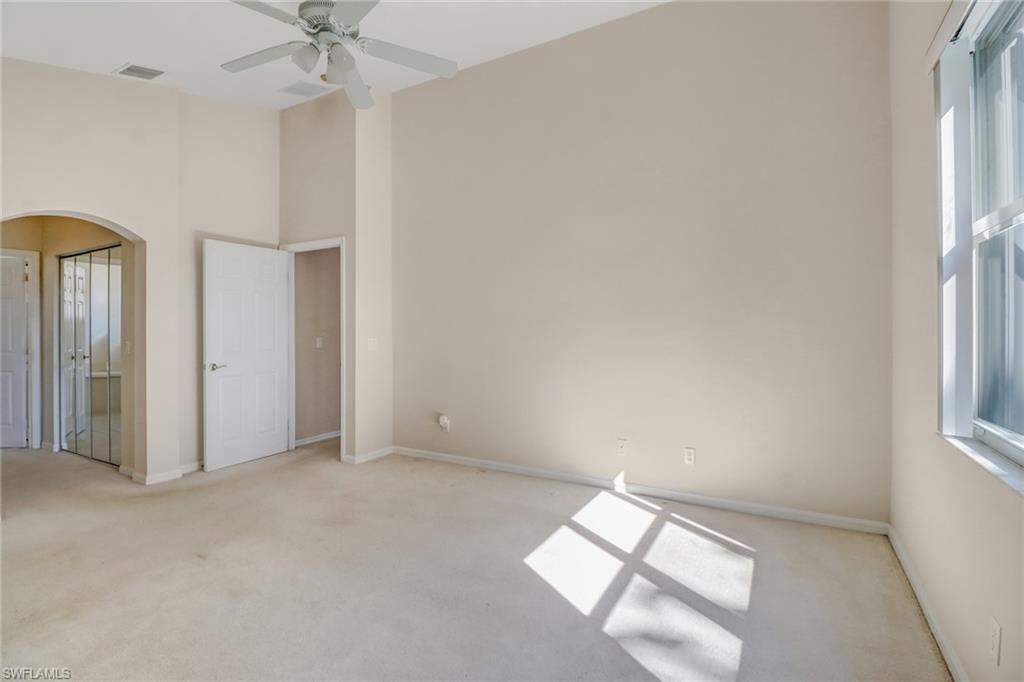 9373 Springview Loop Estero, FL 33928 - Photo 19 of 35 an empty room with chandelier fan and windows