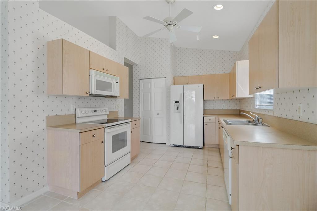 9373 Springview Loop Estero, FL 33928 - Photo 10 of 35 a kitchen with stainless steel appliances granite countertop a sink a stove a refrigerator and cabinets