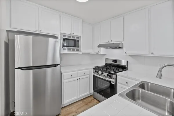 a kitchen with a sink a window and cabinets