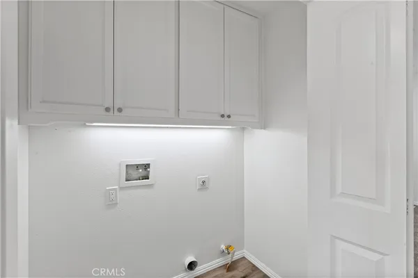 a view of a house with a floor to ceiling window and potted plants