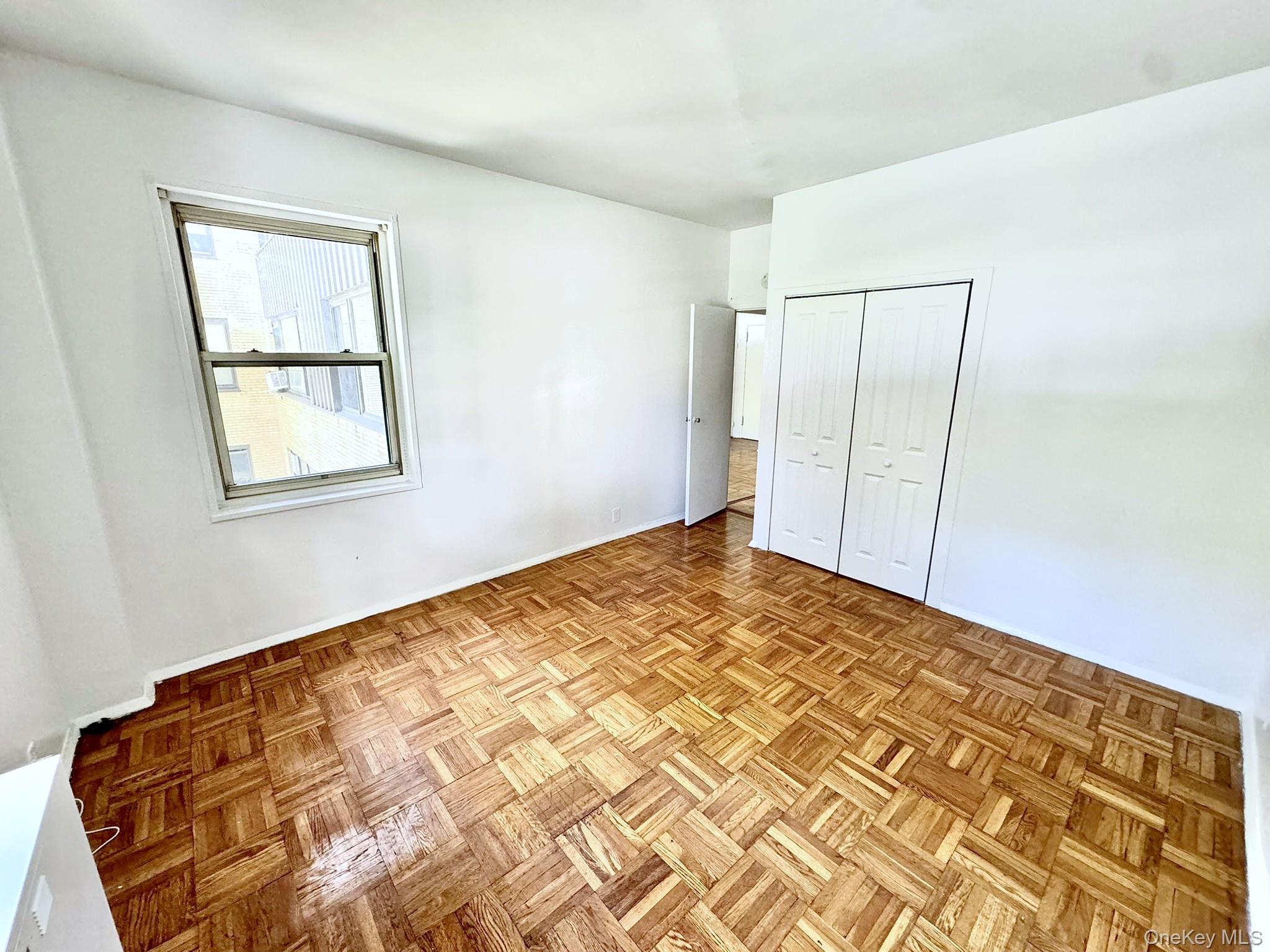 9 Fordham Hill Ovl, Unit 1H Bronx, NY 10468 - Photo 11 of 21 a view of a big room with wooden floor and a window