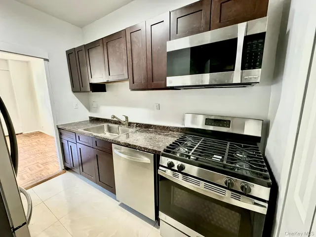 a kitchen with stainless steel appliances granite countertop a stove microwave and sink