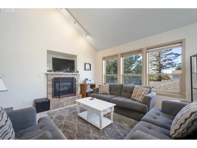 a living room with furniture a large window and a fireplace