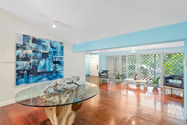 a dining room with wooden floor glass table and chairs