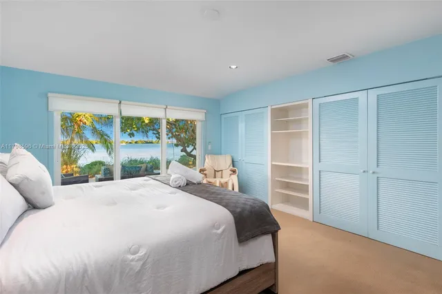 a bedroom with a large bed and a large window