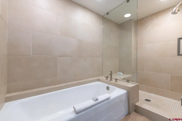 a bathroom with a tub a sink and a shower