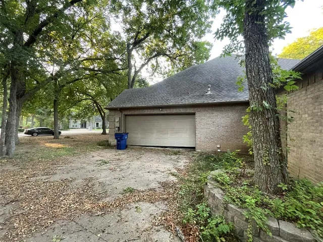 a view of a house with large tree and a area