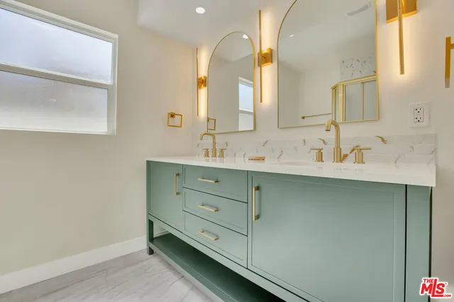 a bathroom with a double vanity sink and a mirror