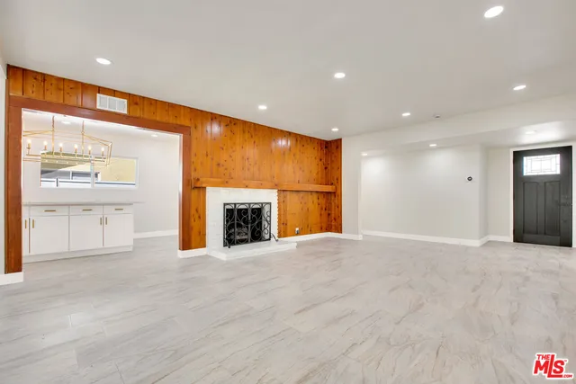 a view of an empty room with a fireplace and a window