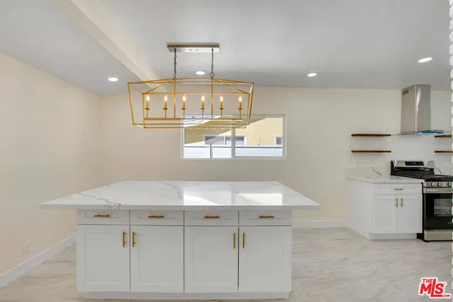 a kitchen with a sink dishwasher a stove a dining table and chairs with wooden floor