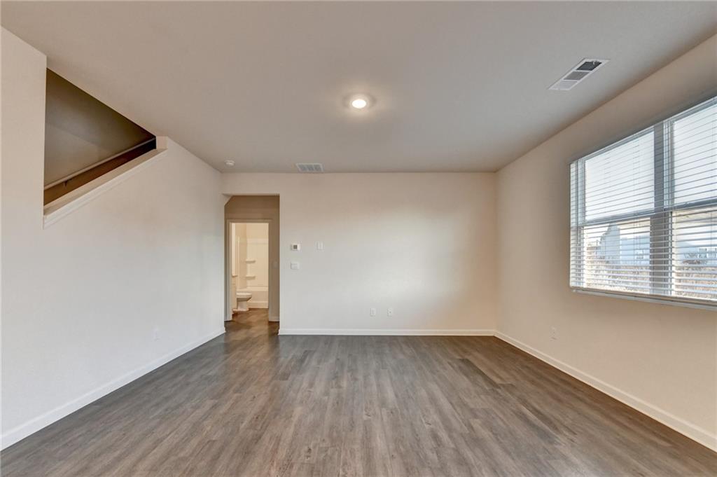 393 Walnut Grv Way Pendergrass, GA 30567 - Photo 16 of 45 a view of an empty room with wooden floor and a window