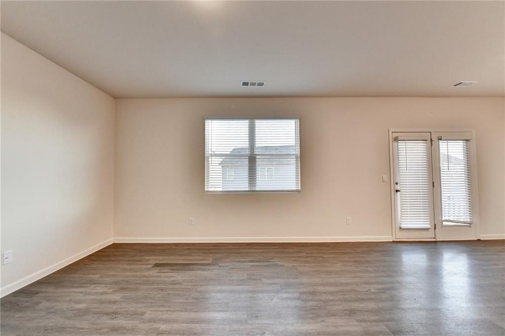 393 Walnut Grv Way Pendergrass, GA 30567 - Photo 17 of 45 an empty room with wooden floor and windows