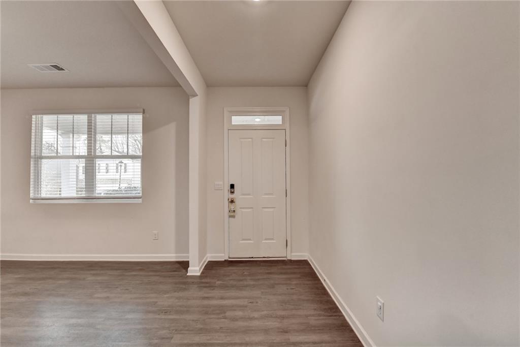 393 Walnut Grv Way Pendergrass, GA 30567 - Photo 4 of 45 an empty room with wooden floor and windows