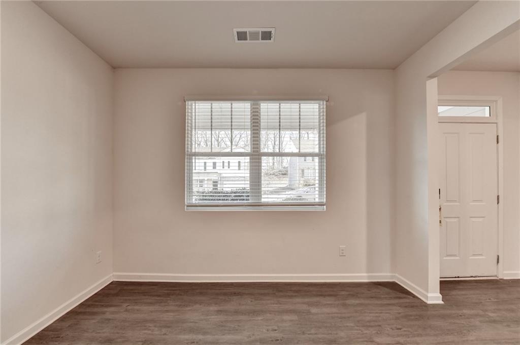 393 Walnut Grv Way Pendergrass, GA 30567 - Photo 5 of 45 an empty room with wooden floor and windows