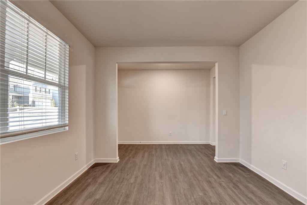 393 Walnut Grv Way Pendergrass, GA 30567 - Photo 6 of 45 a view of an empty room with wooden floor and a window