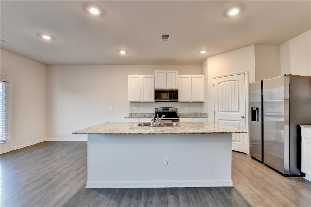 393 Walnut Grv Way Pendergrass, GA 30567 - Photo 8 of 45 a kitchen with stainless steel appliances a sink stove refrigerator and cabinets