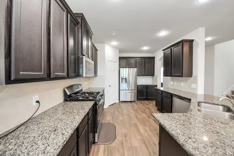 a large kitchen with stainless steel appliances kitchen island granite countertop a large island in the center