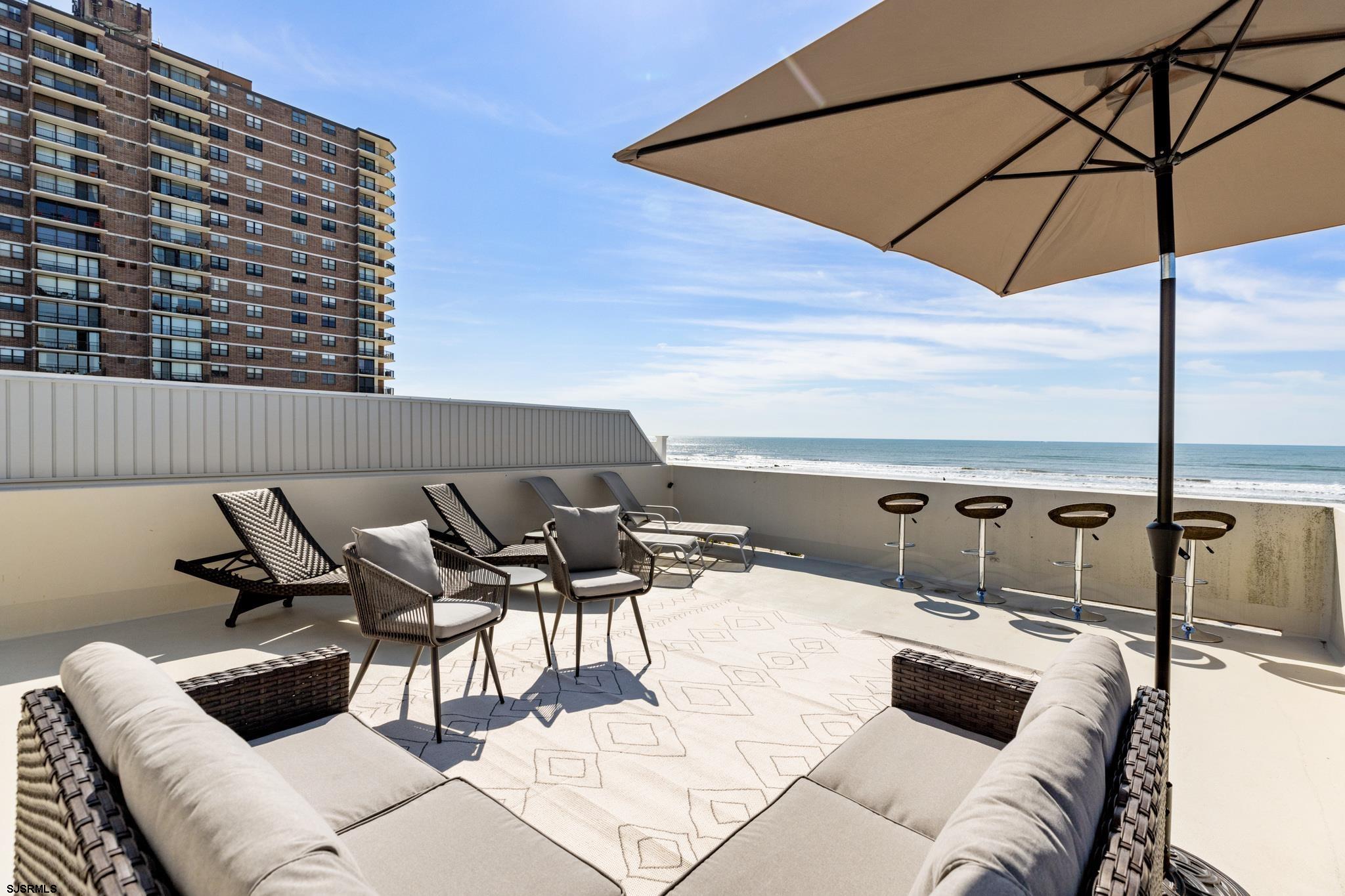 111 South Decatur Avenue Margate City, NJ 08402 - Photo 29 of 39 a roof deck with couches under an umbrella