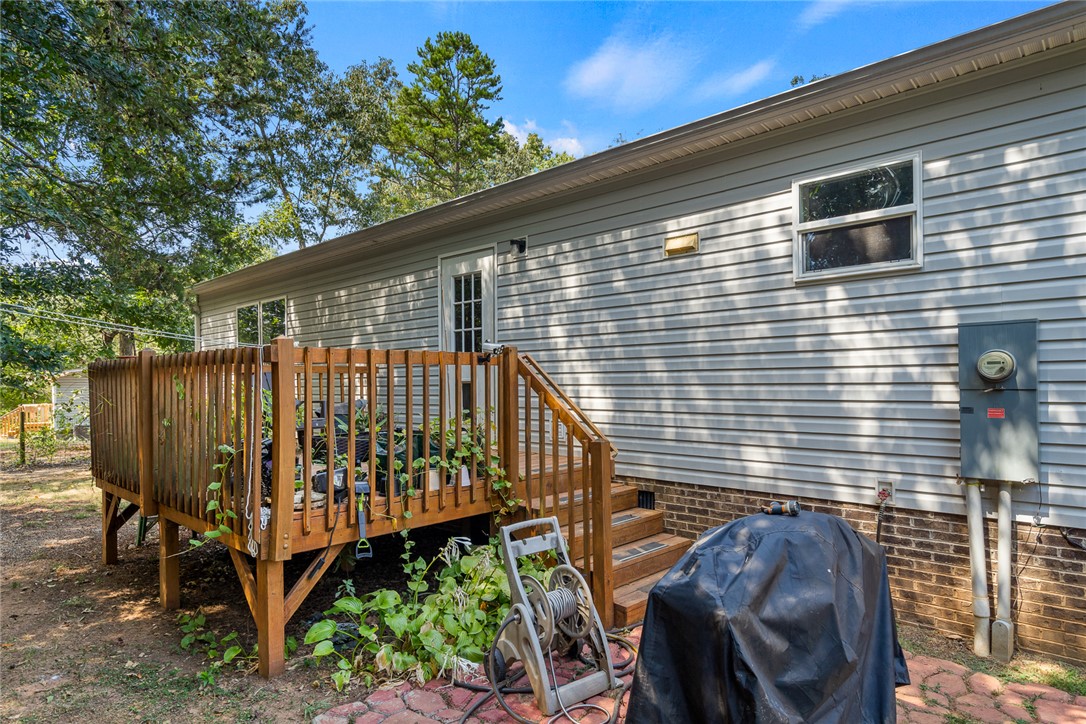 429 Gibson Road Anderson, SC 29625 - Photo 34 of 47 An elevated wooden deck extends from the vinyl-sided exterior, overlooking a shady yard.