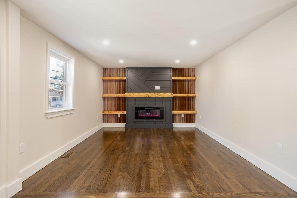 79 Bonham Road Dedham, MA 02026 - Photo 8 of 28 a view of an empty room with a fireplace and a window